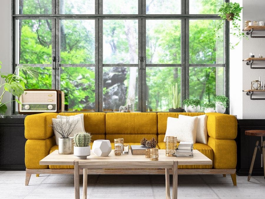 Image of a home with a yellow couch and a big window. Air Duct Cleaning.